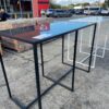 EX HIRE, BLACK METAL BAR TABLE WITH BLACK STONE TOP, SOLD AS IS