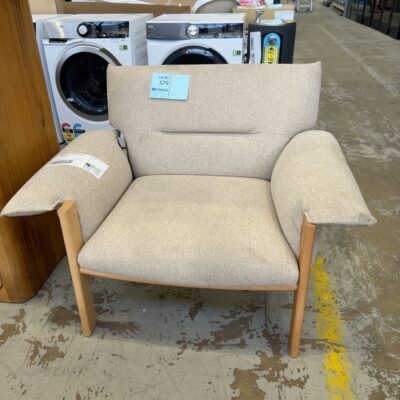 EX HIRE - CREAM/TAN MATERIAL ARMCHAIR WITH TIMBER FRAME, ***TEAR IN ARM***SOLD AS IS